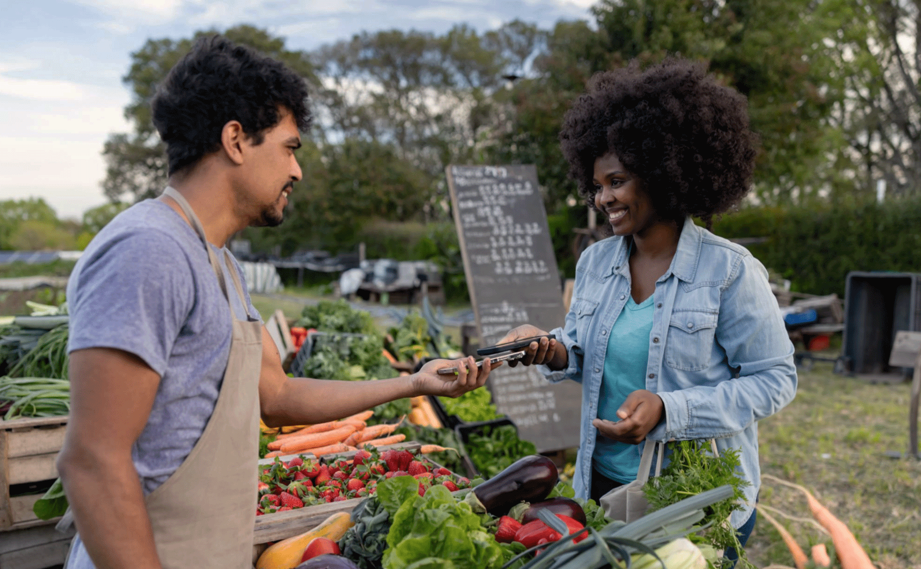 Shopper and seller using a mobile POS system at a farmers market with YELL.